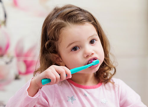 Niña pequeña lavándose los dientes