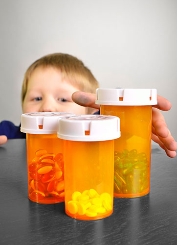 Niño tratando de tomar unas cajas de pastillas